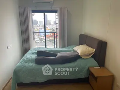 Cozy bedroom with city view, featuring a comfortable bed and modern decor.