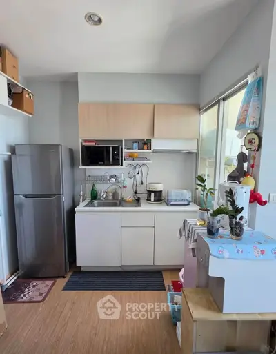 Cozy kitchen with modern appliances and ample storage in a bright, compact space.