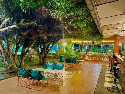 Charming outdoor patio with lush greenery and cozy seating, perfect for relaxation and entertaining.