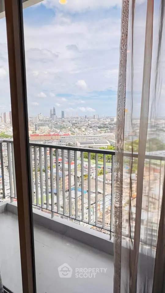 Stunning city view from high-rise apartment balcony with sheer curtains