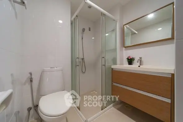 Modern bathroom with glass shower and wooden vanity