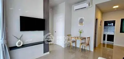 Modern living room with wall-mounted TV and dining area in stylish apartment.