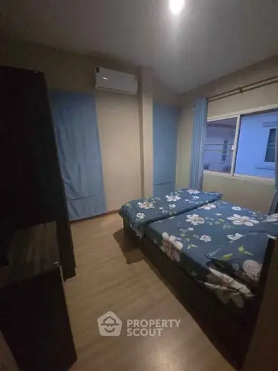 Cozy bedroom with floral bedding and air conditioning, perfect for restful nights.