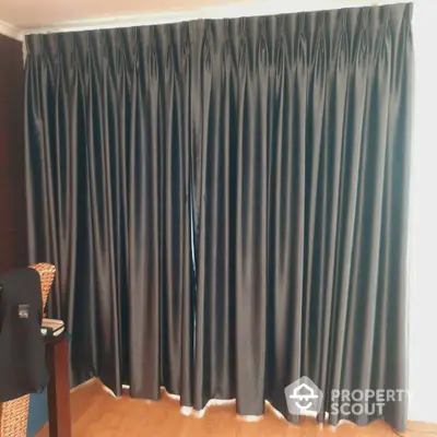 Elegant floor-to-ceiling dark curtains in a cozy interior setting.