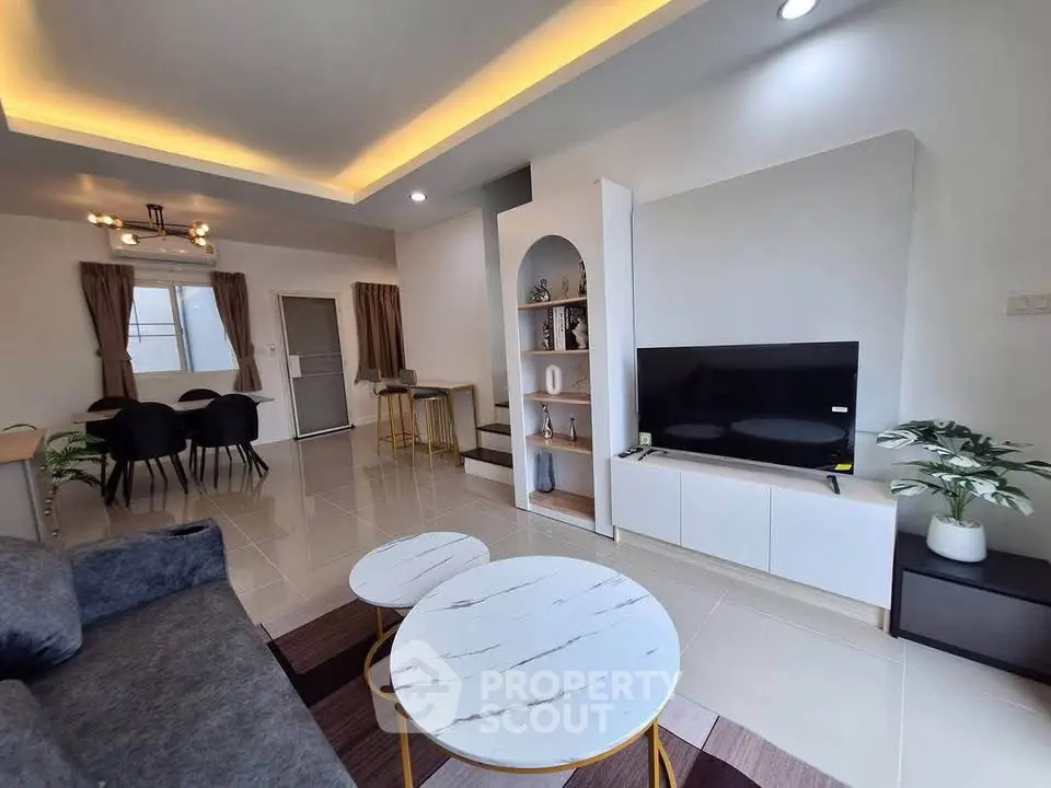 Modern living room with stylish decor and open layout, featuring a cozy seating area and elegant dining space.