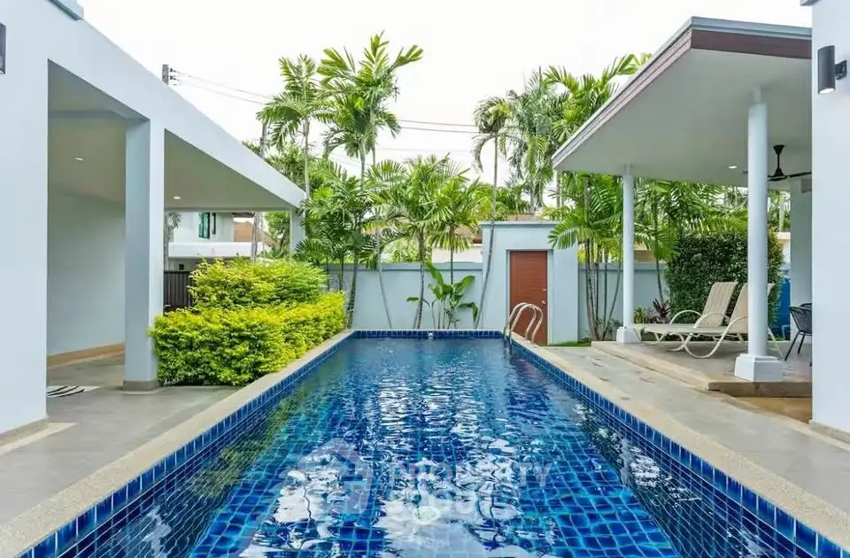 Luxurious private pool surrounded by lush greenery and modern architecture, perfect for relaxation and entertainment.