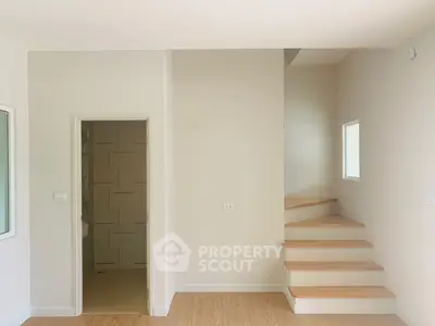 Modern minimalist interior with wooden staircase and neutral tones