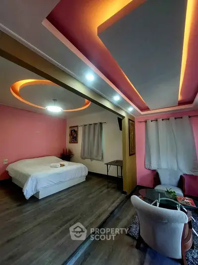 Luxurious bedroom with modern lighting and stylish decor, featuring a cozy seating area and elegant flooring.