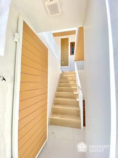 Modern staircase with wooden accents in bright, minimalist interior design