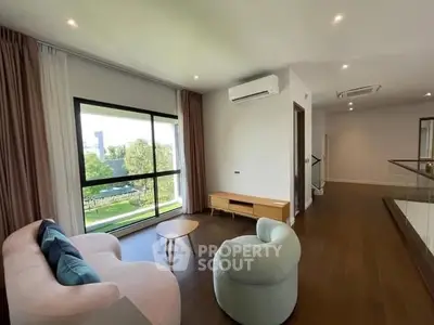 Spacious living room with modern furniture and large window view