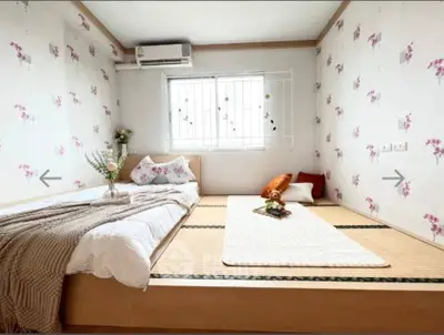 Charming bedroom with tatami flooring and floral wallpaper, perfect for a cozy retreat.