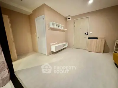 Modern minimalist living room with light wood flooring and sleek storage solutions.