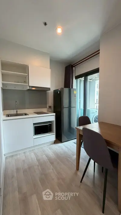 Modern kitchen with sleek appliances and dining area in a stylish apartment.