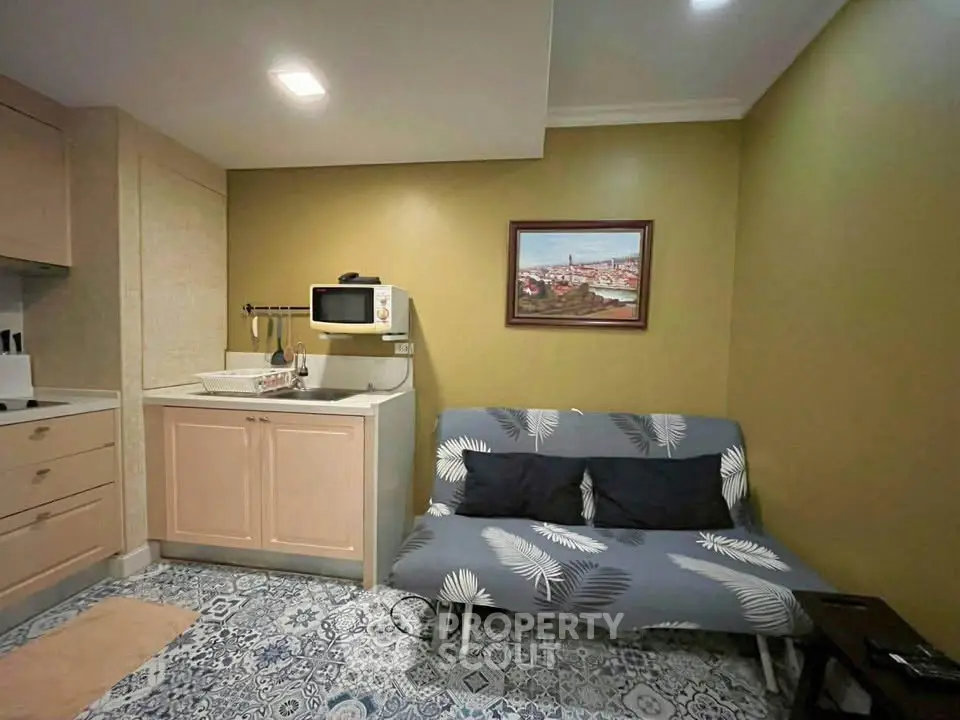 Cozy living room with stylish decor and compact kitchen area, perfect for modern urban living.