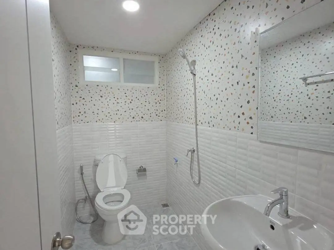 Modern bathroom with terrazzo wall tiles and sleek fixtures