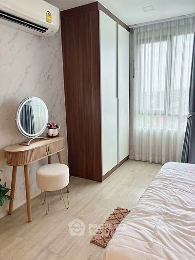 Cozy bedroom with modern decor, featuring a stylish vanity and ample natural light.