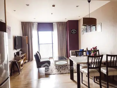 Spacious living room with modern decor and dining area, featuring large windows and stylish furniture.