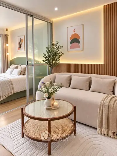 Modern living room with cozy sofa, stylish decor, and view into elegant bedroom through glass doors.