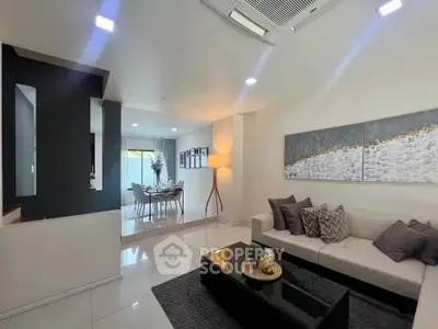Modern living room with elegant decor and open layout leading to dining area.