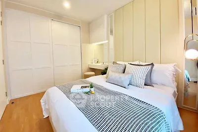 Modern bedroom with cozy bed, stylish decor, and ample closet space in a bright apartment.
