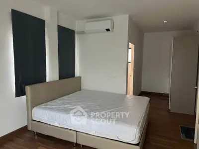 Spacious bedroom with modern air conditioning and large bed, perfect for comfort and relaxation.