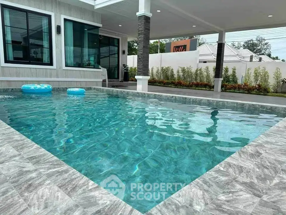 Luxurious modern home with sparkling pool and stylish outdoor area, perfect for relaxation and entertainment.