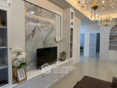Elegant living room with marble accent wall and chandelier lighting
