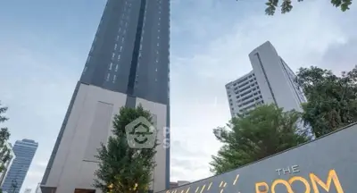 Modern high-rise building with lush greenery and elegant entrance signage.