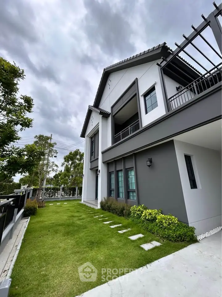 Modern two-story house with lush green lawn and contemporary design