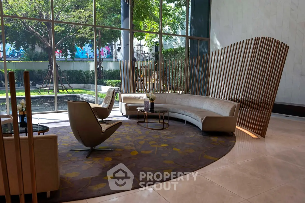 Luxurious modern lobby with elegant seating and large windows overlooking lush greenery.