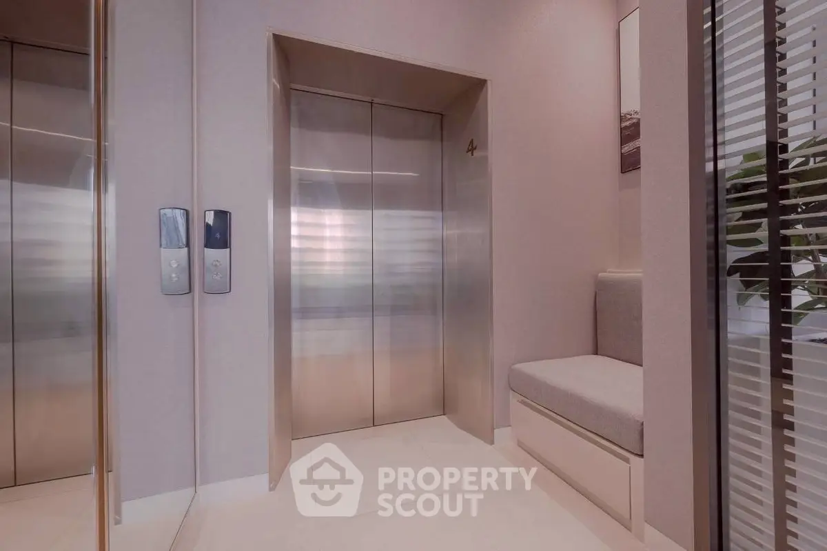 Modern building elevator lobby with sleek design and comfortable seating area.