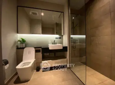 Modern bathroom with sleek design, featuring a glass shower and stylish fixtures.