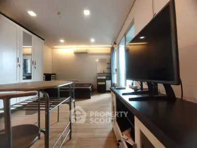 Modern living room with sleek furniture and large TV, perfect for relaxation and entertainment.