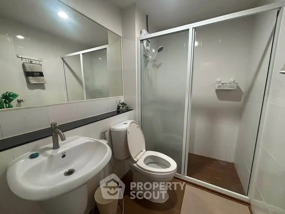Modern bathroom with glass shower enclosure and sleek fixtures
