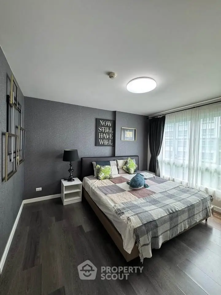 Modern bedroom with stylish decor and large windows offering natural light.