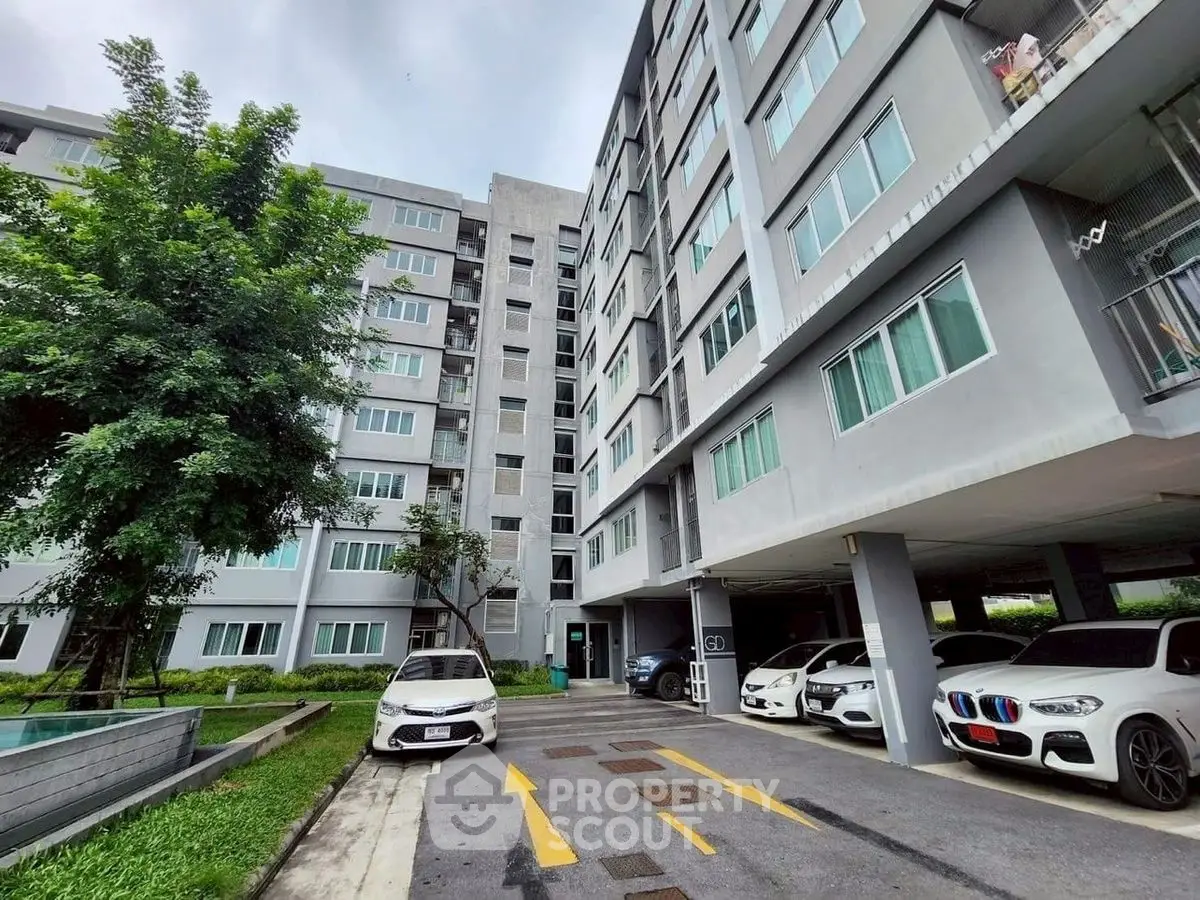 Modern apartment building with parking and lush greenery