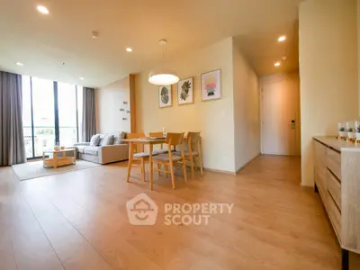 Spacious modern living room with dining area and large windows in a stylish apartment.