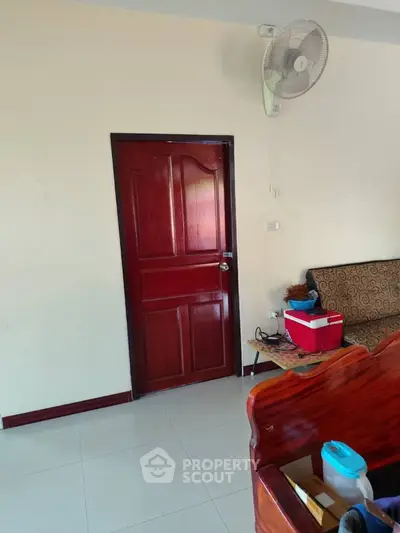 Cozy living room with wooden door and wall-mounted fan, perfect for comfortable living.