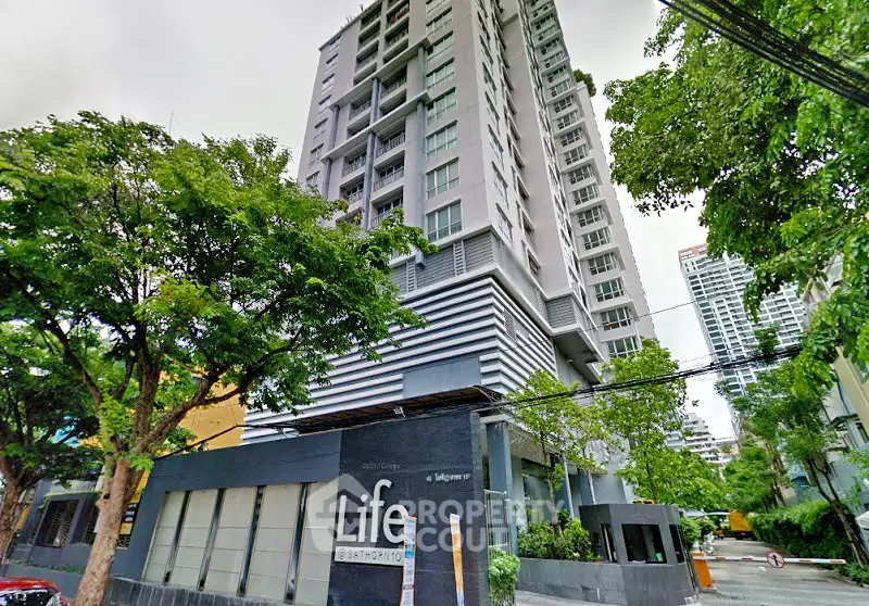 Modern high-rise residential building with lush greenery and urban appeal.