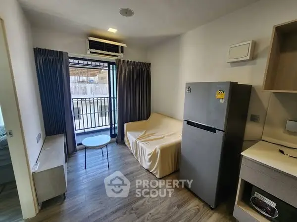 Modern living room with balcony access and sleek furnishings in a stylish apartment.