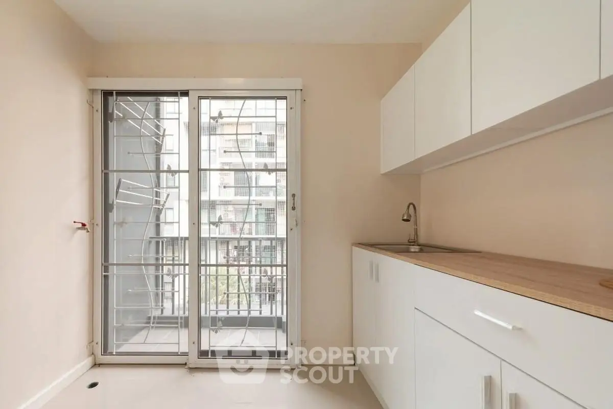 Modern kitchen with sleek cabinets and balcony access