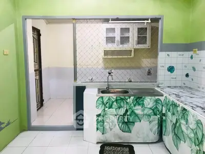 Charming kitchen with unique green leaf decor and open layout, perfect for culinary enthusiasts.