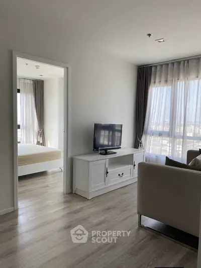 Modern living room with TV and large windows in a bright apartment