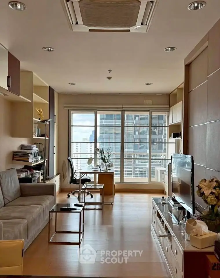 Modern living room with city view, featuring sleek furniture and natural light.