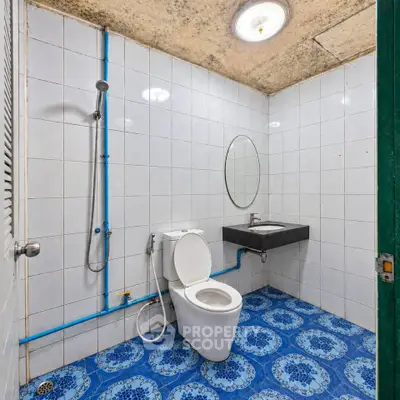 Spacious bathroom with unique blue tile flooring and modern fixtures.