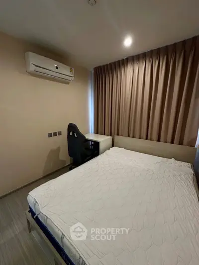 Cozy bedroom with modern air conditioning and work desk, ideal for comfort and productivity.