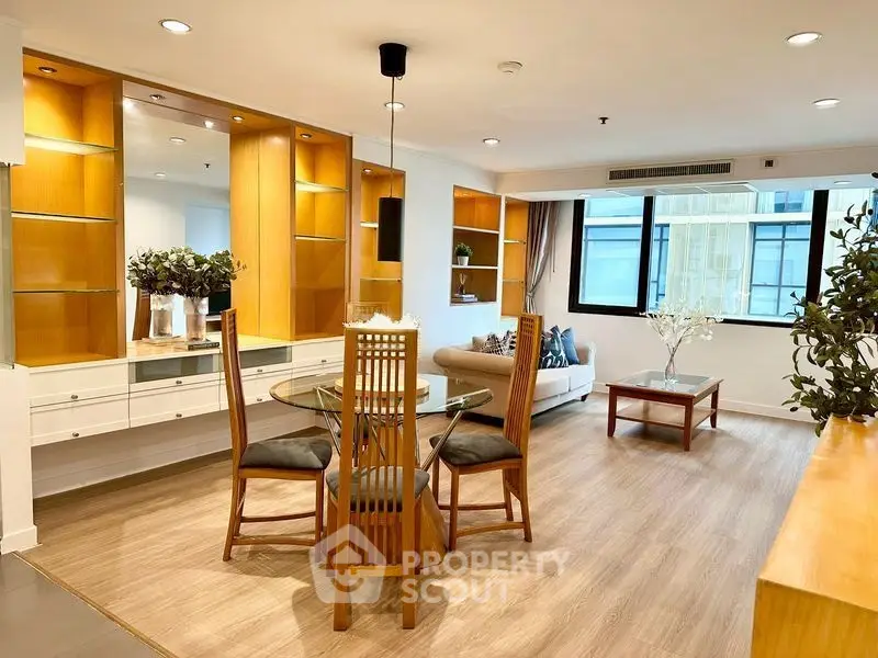 Spacious living room with elegant dining area and modern decor in a bright apartment.