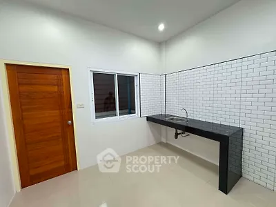 Modern minimalist kitchen with sleek black countertop and white subway tiles.