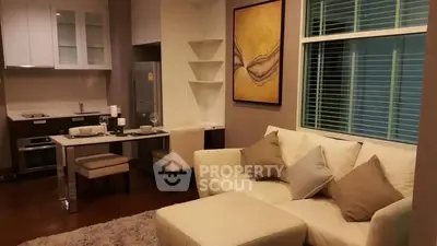 Modern living room with open kitchen, cozy sofa, and stylish decor in a contemporary apartment.