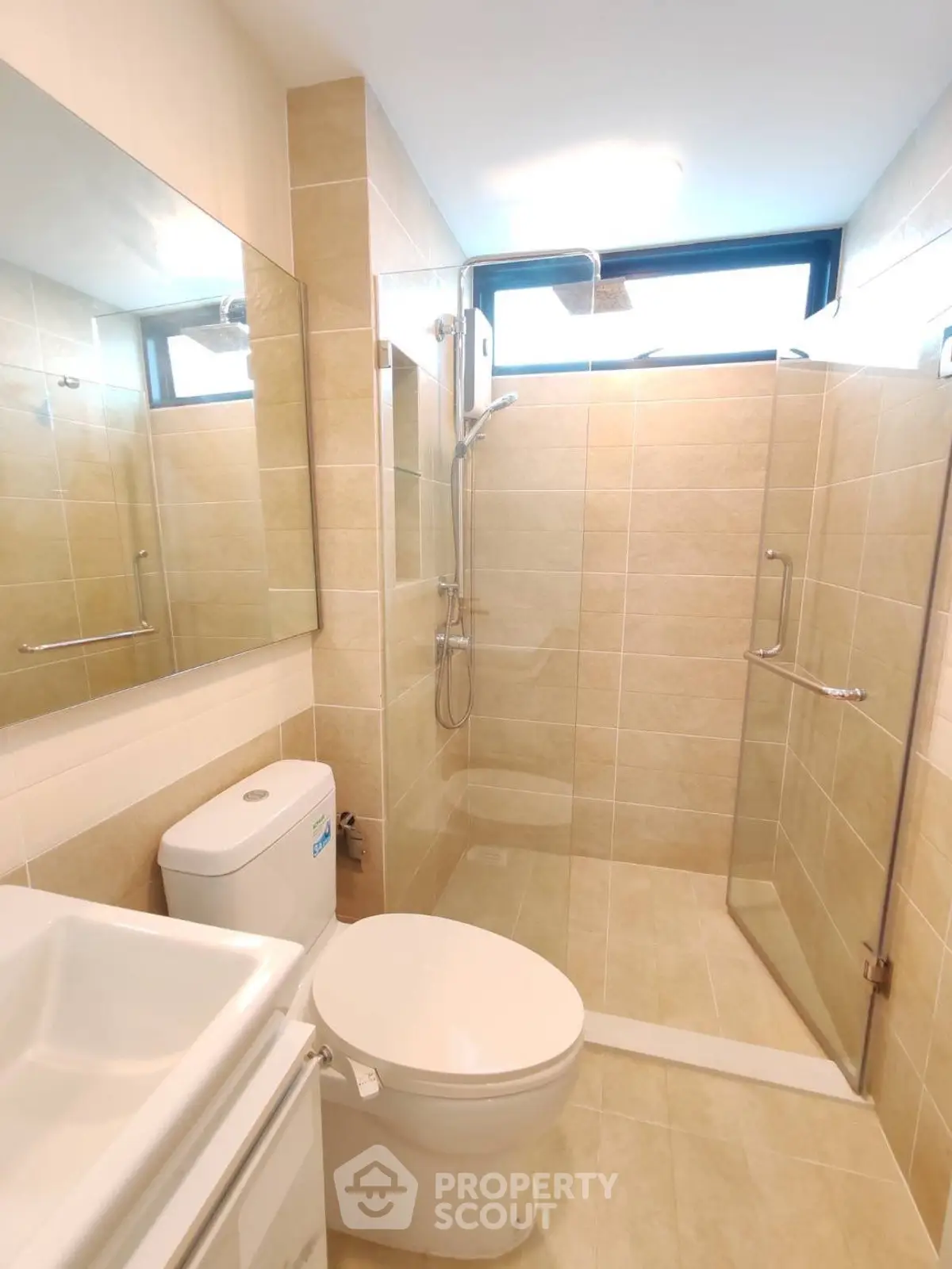 Modern bathroom with glass shower and large mirror in a stylish apartment.
